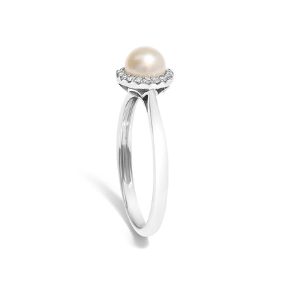 Silver ring with a white pearl centerpiece and a halo of small diamonds on a plain background.