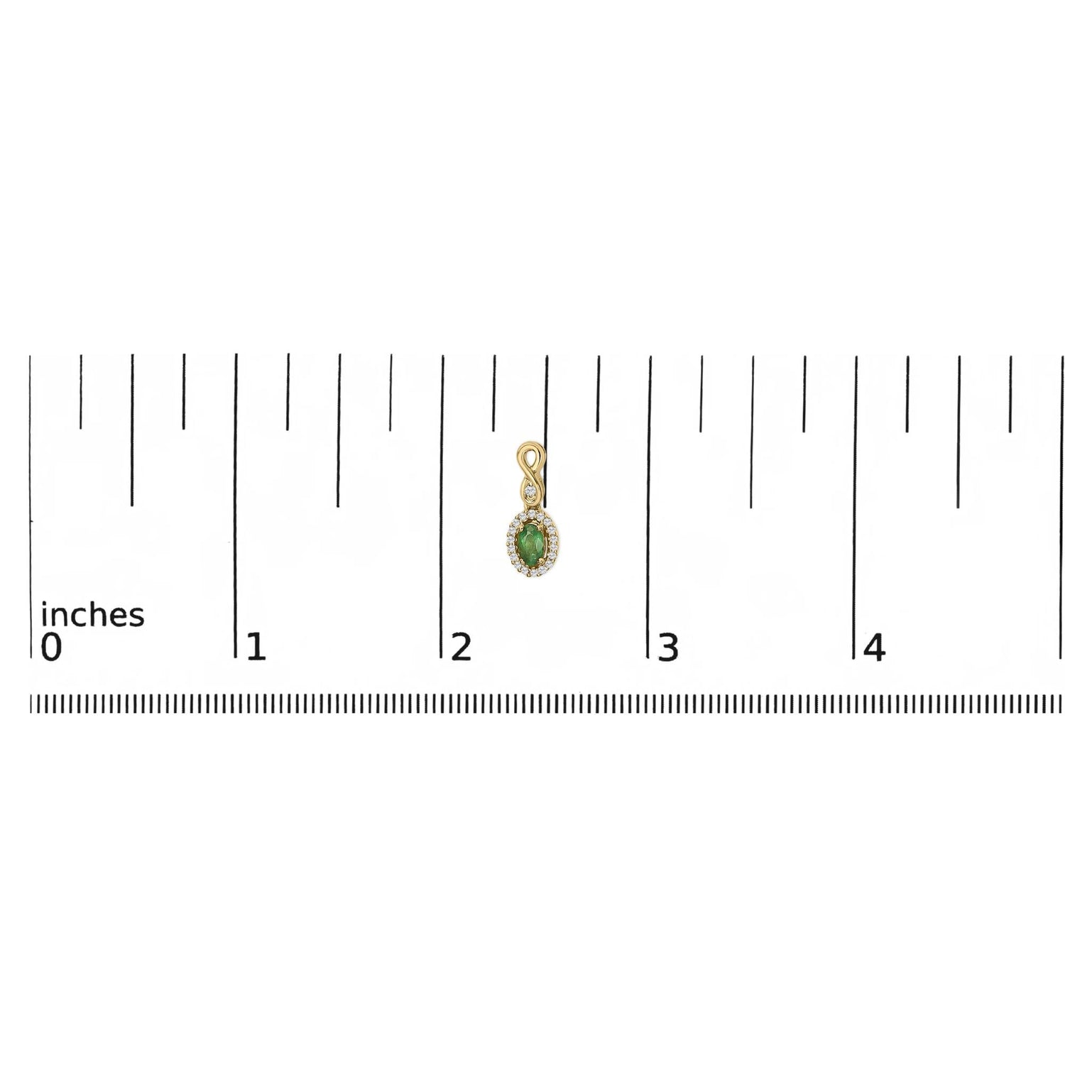 Small gold pendant with green gem, surrounded by clear stones, next to a ruler showing about 2 inches.