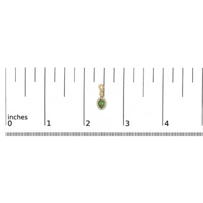 Small gold pendant with green gem, surrounded by clear stones, next to a ruler showing about 2 inches.