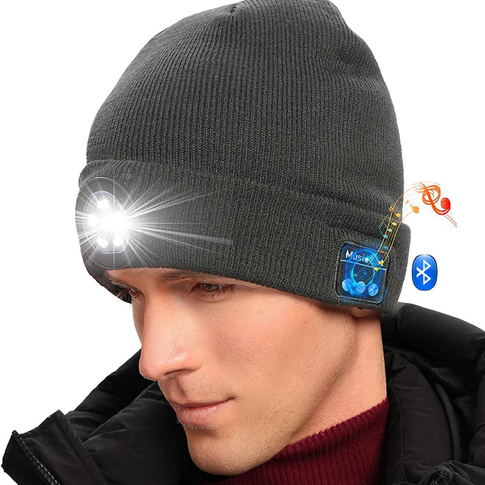 Man wearing black beanie with LED light and Bluetooth icon, musical notes, on a white background.
