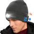 Man wearing black beanie with LED light and Bluetooth icon, musical notes, on a white background.