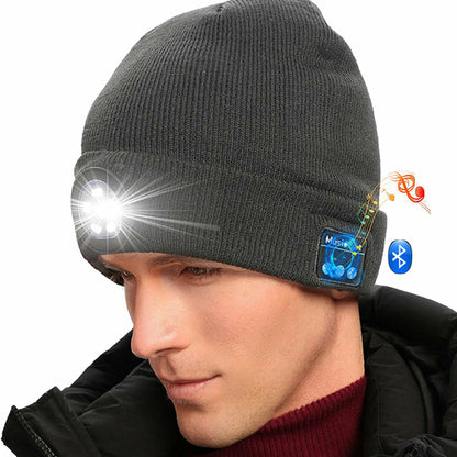 Man in gray beanie with built-in LED light and Bluetooth symbol, wearing a black coat.