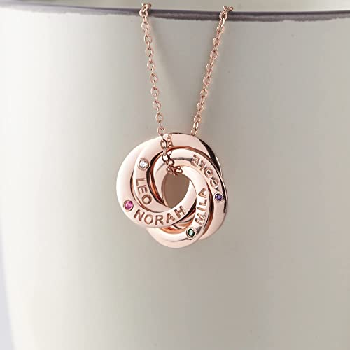 Rose gold necklace with three interlocking rings engraved with names and inset with small gems.