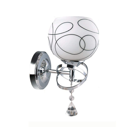Wall sconce with white globe, black swirl pattern, chrome mount, and crystal hanging drop.