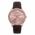 Rose gold watch with crystal accents, zebra pattern dial, and dark brown leather strap.