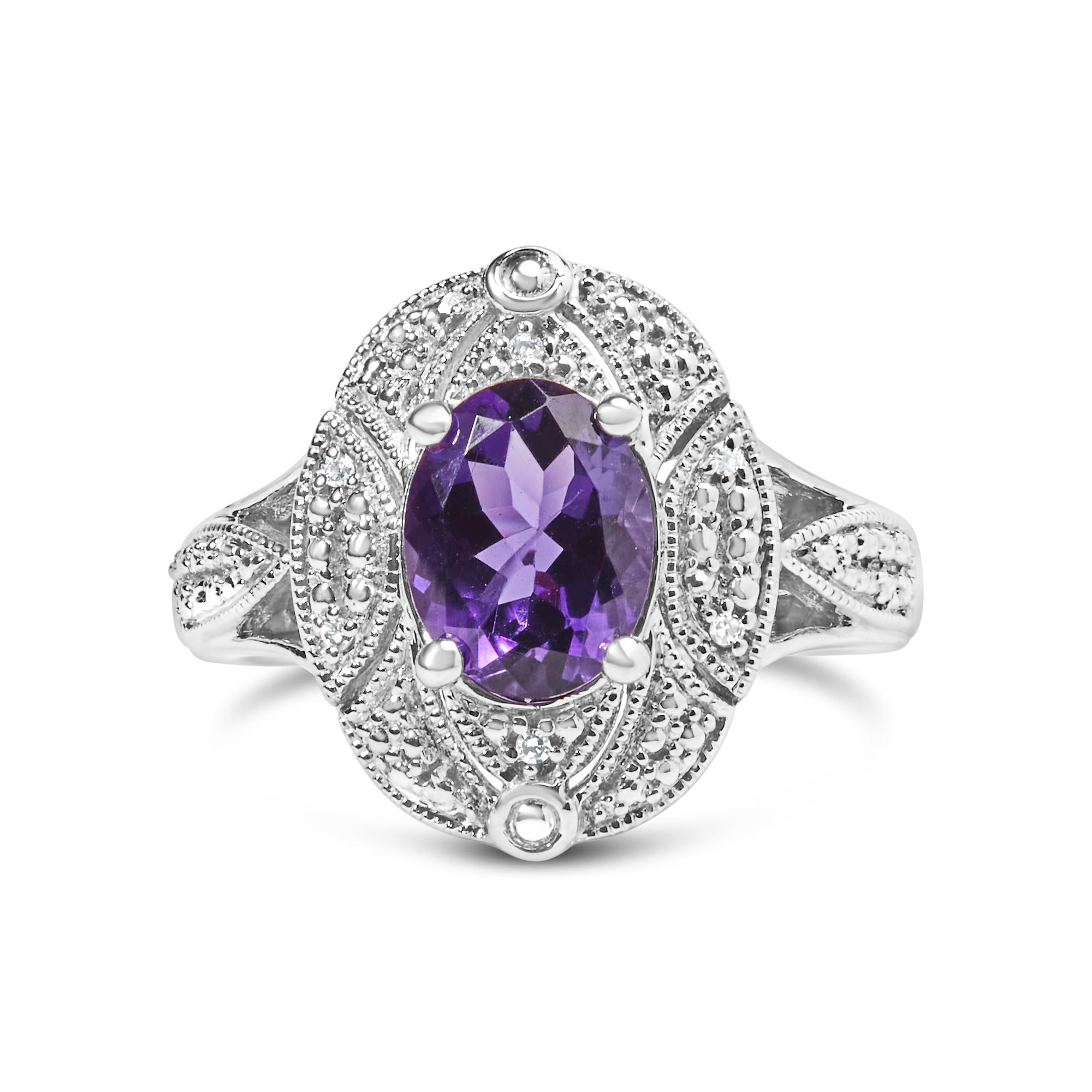 Silver ring with intricate patterns, featuring an oval purple gemstone at the center.