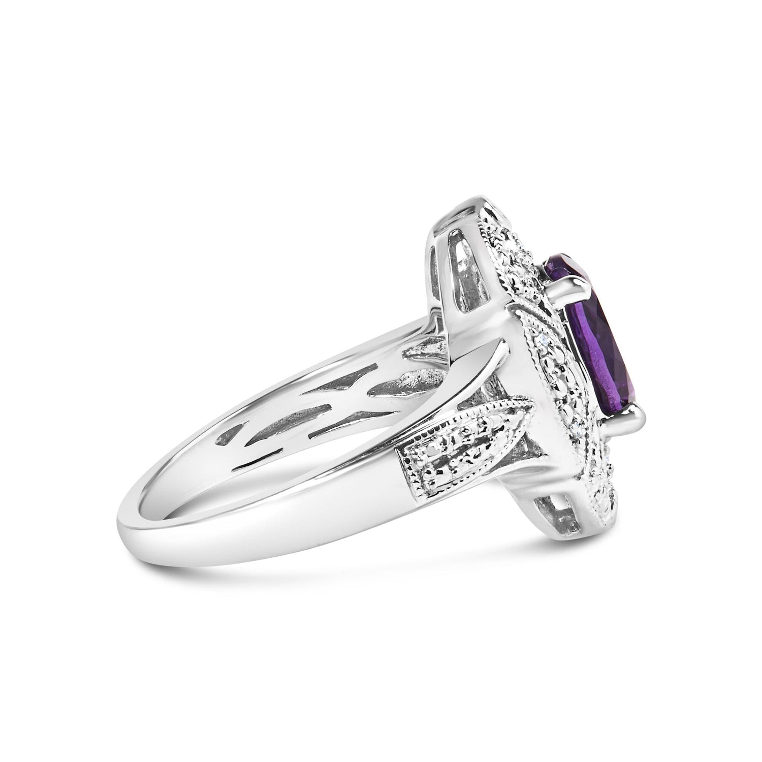 Silver ring with intricate design, featuring a purple gemstone and small clear stones.