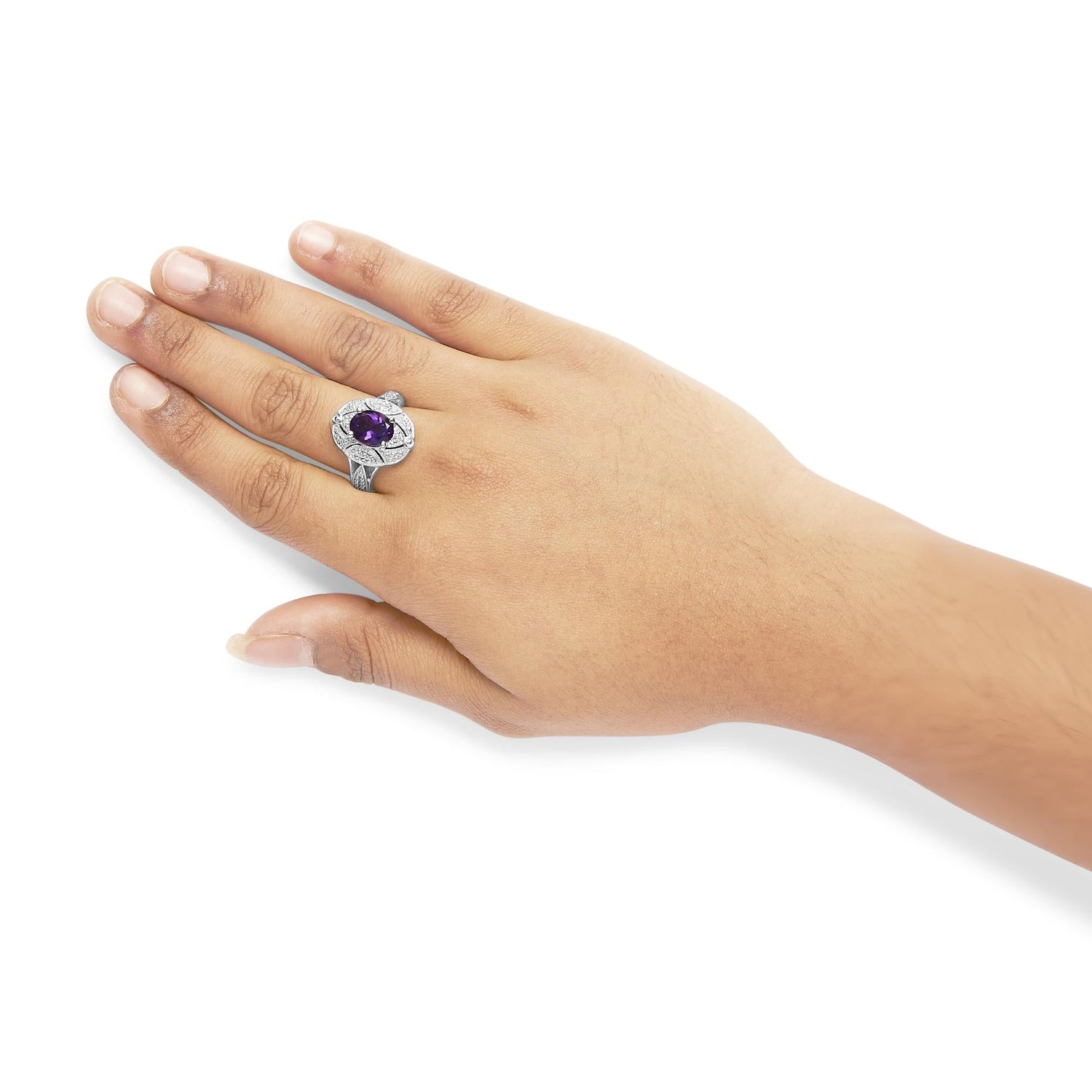 Hand wearing a silver ring with a large purple gemstone, on a white background.