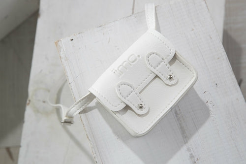 Small white leather bag with a strap on a wooden surface. Two buckles and logo on the flap.