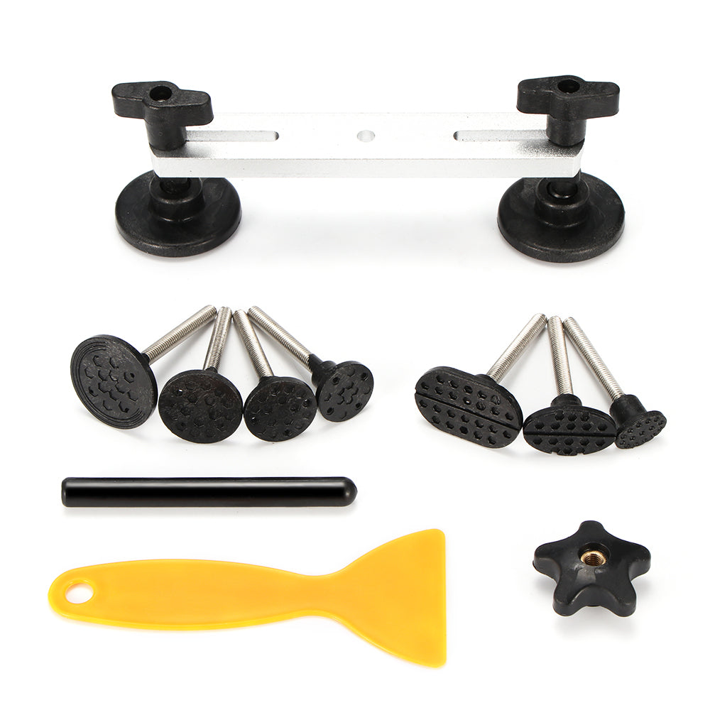 Black car dent repair tools with suction cups, a yellow scraper, and various attachments.