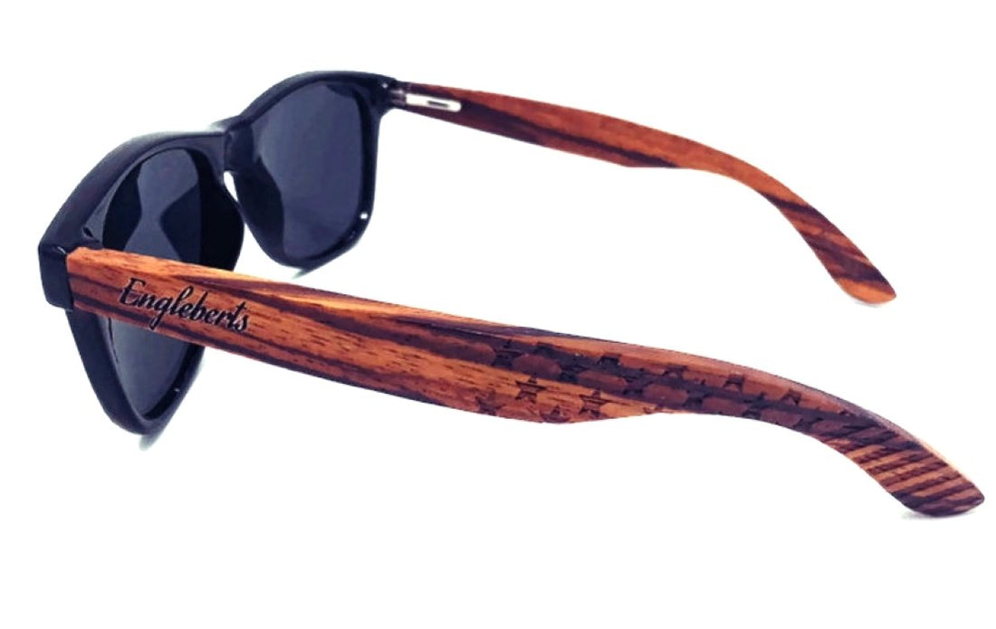 Sunglasses with black lenses, glossy black frame, and brown wood-patterned arms with branding.