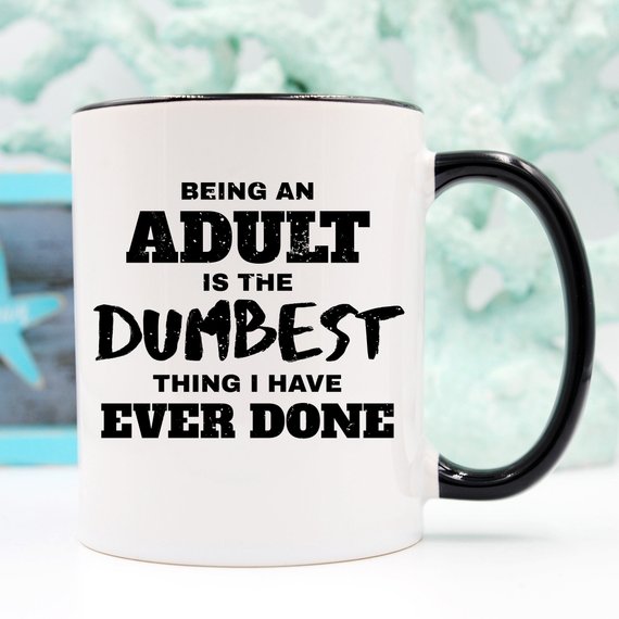 White mug with black handle, text reads: "Being an adult is the dumbest thing I have ever done."
