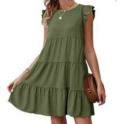 Woman in olive green tiered dress with ruffled sleeves, holding a brown round bag.
