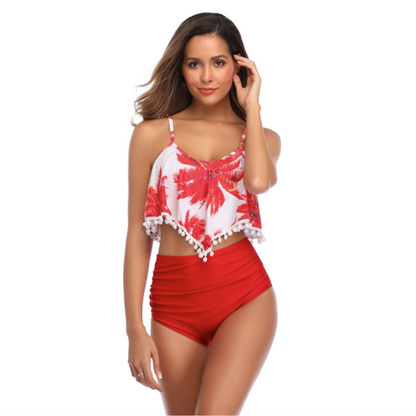 Woman in a red floral bikini top with pom-poms and red high-waisted bottom, smiling and posing.