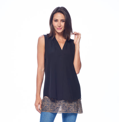Woman in black sleeveless top with leopard print hem, blue jeans, posing against white background.