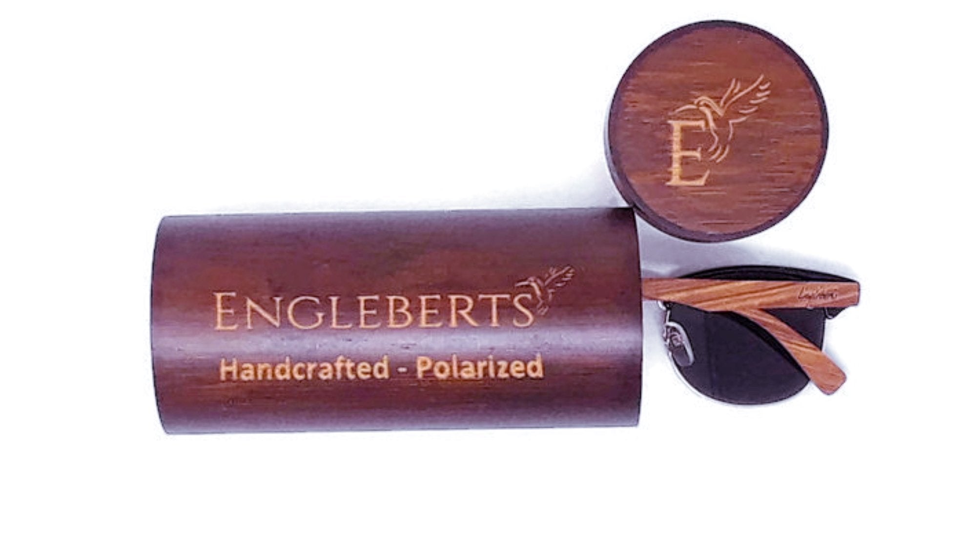 Wooden sunglasses case with engraved text, round lid, and partially visible sunglasses.