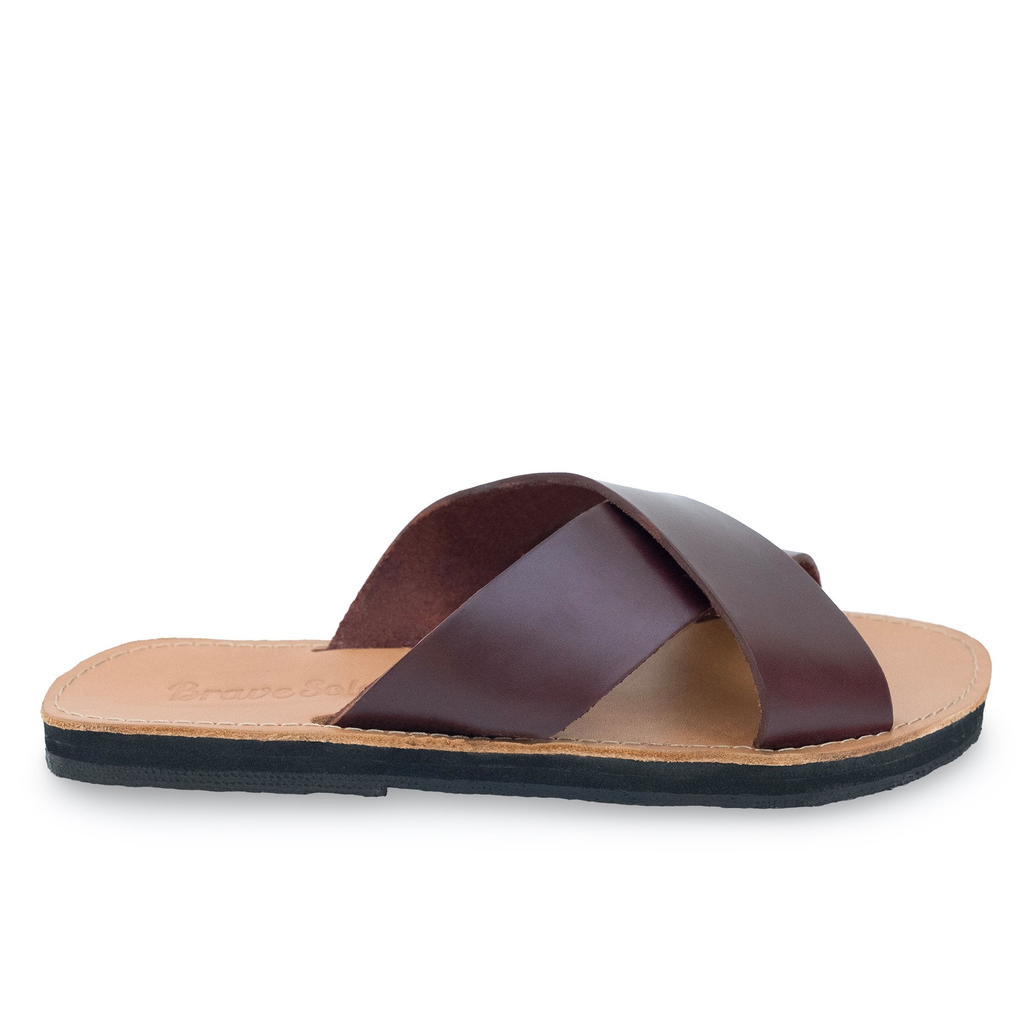 Brown leather sandal with crisscross straps on a tan sole, black outsole, side view.