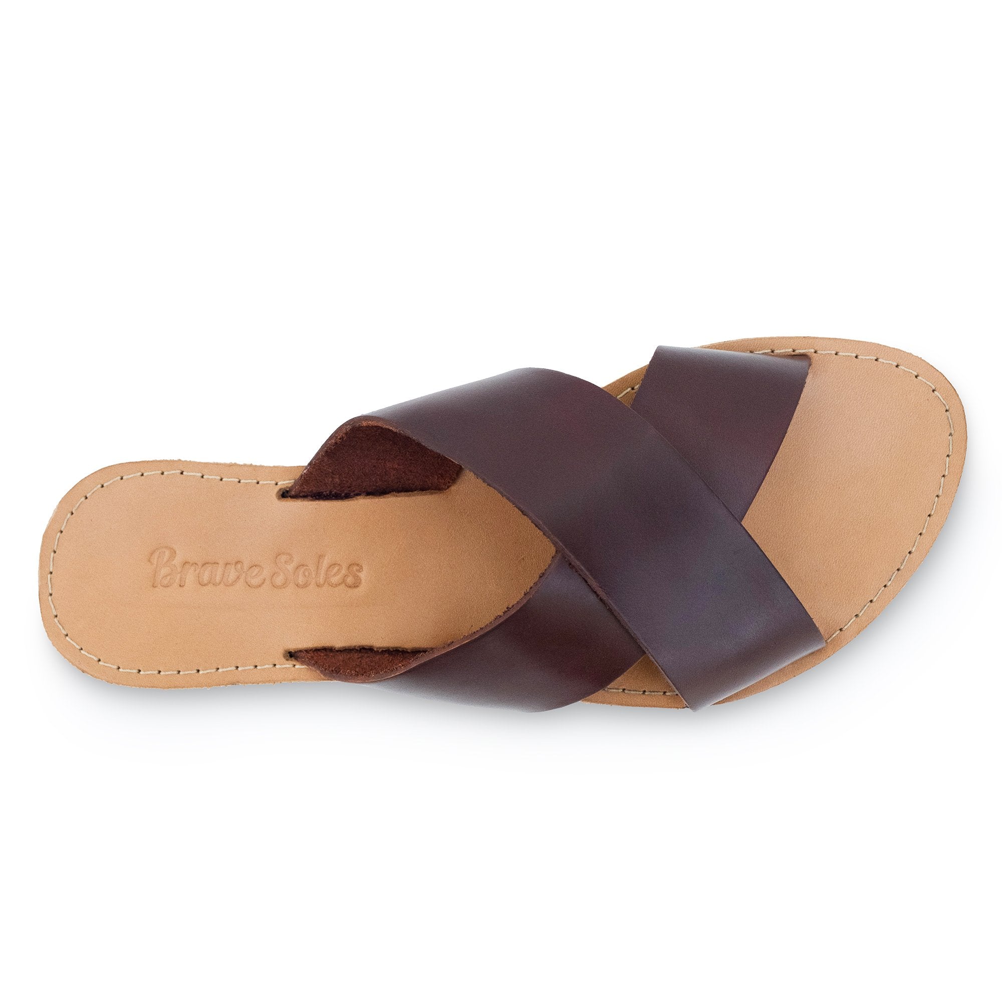 Brown leather sandal with crisscross straps on a tan sole, embossed "Brave Soles" text.