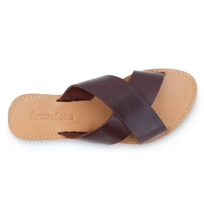 Brown leather sandal with crisscross straps on a tan sole, embossed "Brave Soles" text.