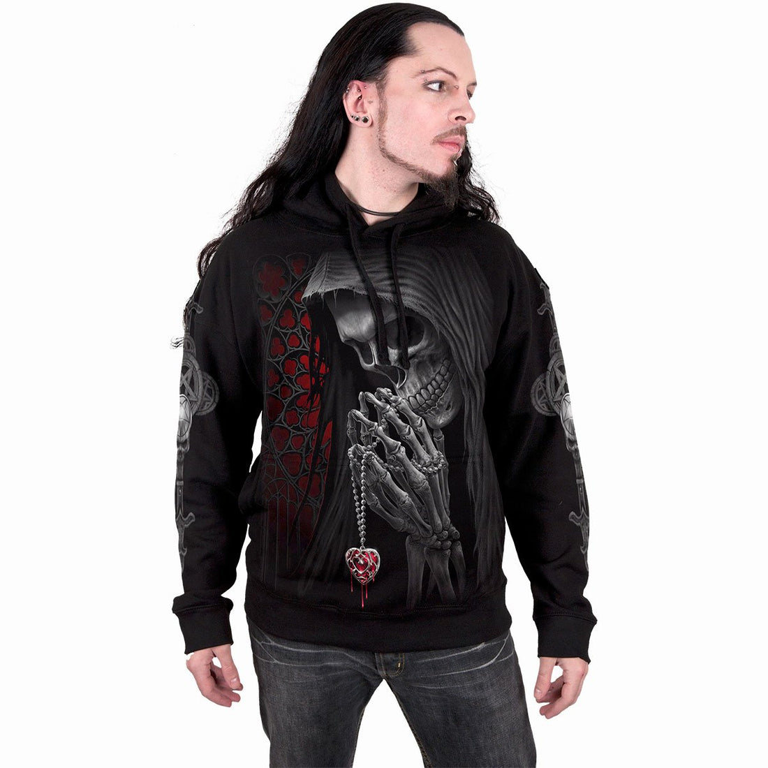 Man in a black hoodie with a praying skeleton design, red accents, long dark hair, and jeans.