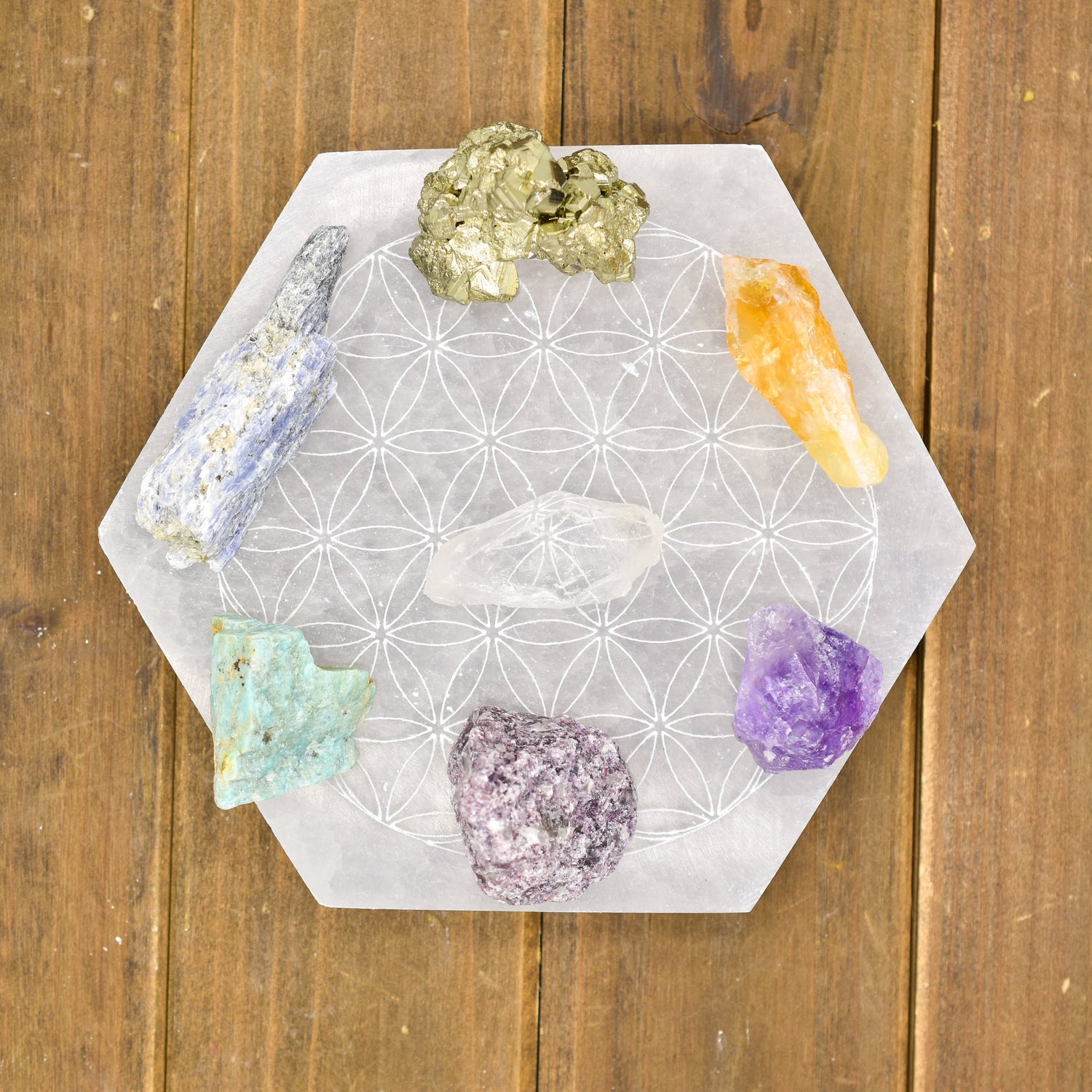 Hexagonal board with colorful crystals on wood background; includes purple, orange, and green stones.