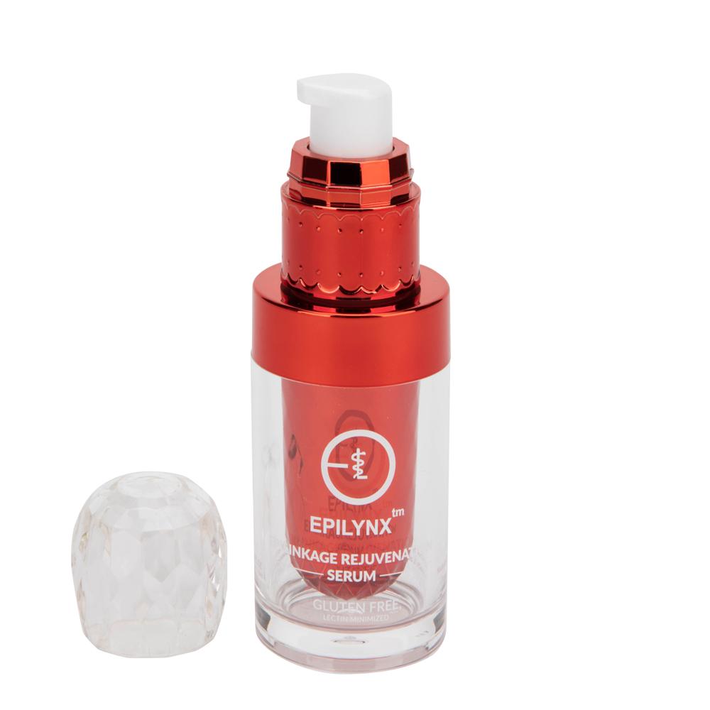 Clear serum bottle with metallic red pump and white dispenser, cap beside it on white background.