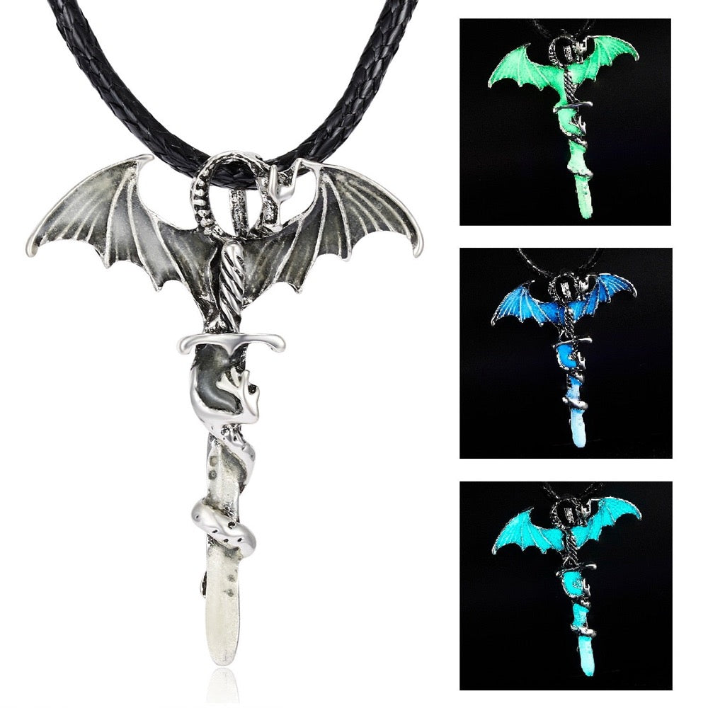 Silver bat-winged pendant with serpent, shown glowing in green and blue on a woven black cord.