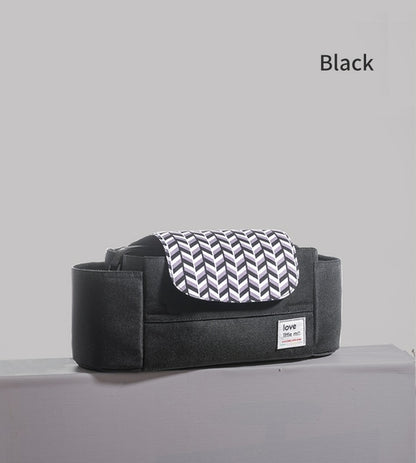 Black bag with white chevron-patterned flap on a gray surface, labeled "love."