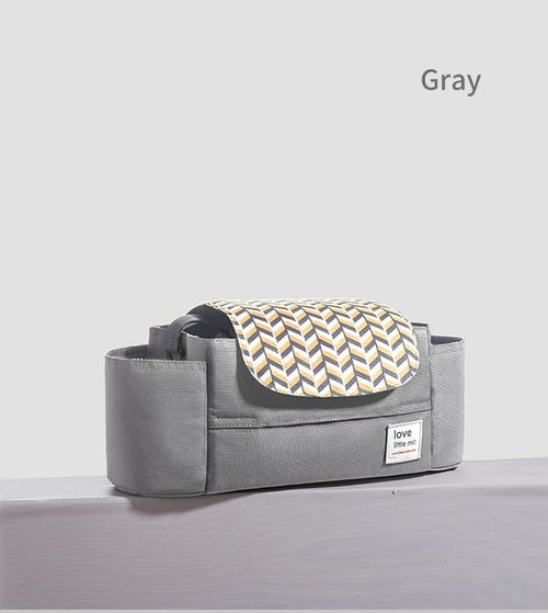 Gray organizer with a geometric-patterned flap in yellow and blue hues, set on a plain surface.