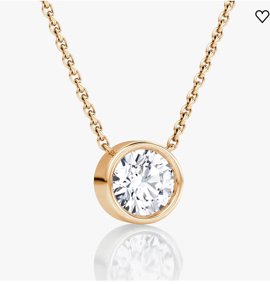 Gold chain necklace with a round diamond pendant in gold bezel setting, on a white background.