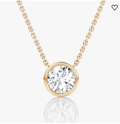 Gold chain necklace with a large round diamond pendant in a sleek bezel setting, on a white background.