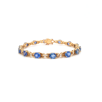 Gold bracelet with blue gemstone links, arranged in a circular pattern on a white background.