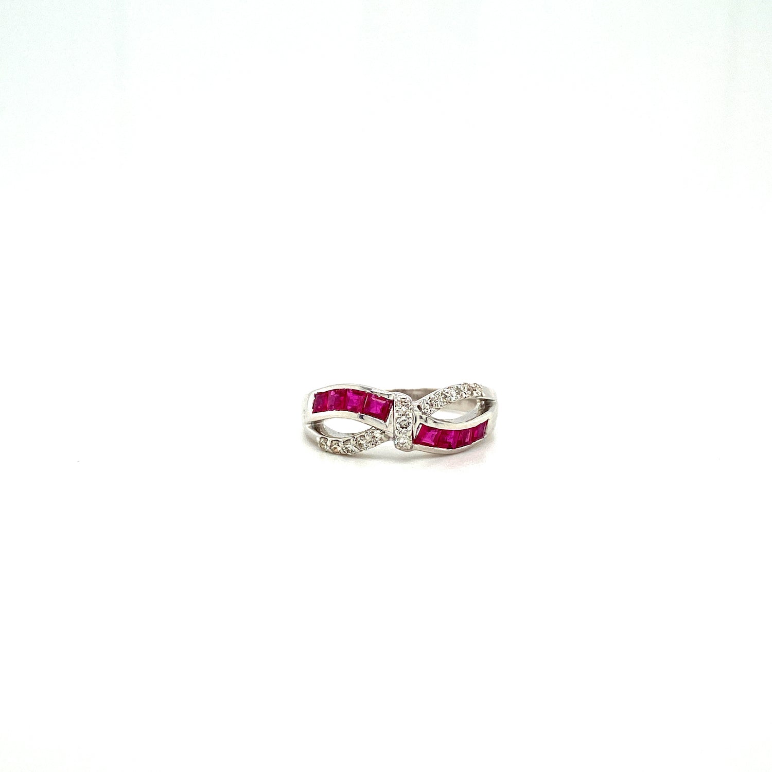 Silver infinity ring with red stones and clear crystals on a white background.