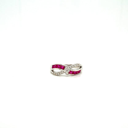 Silver infinity ring with red stones and clear crystals on a white background.