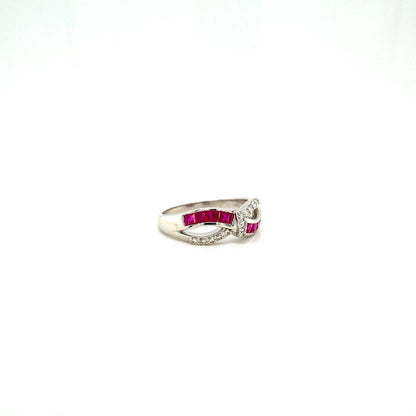 Silver ring with red rectangular stones and small white stones in a twisted design on white background.