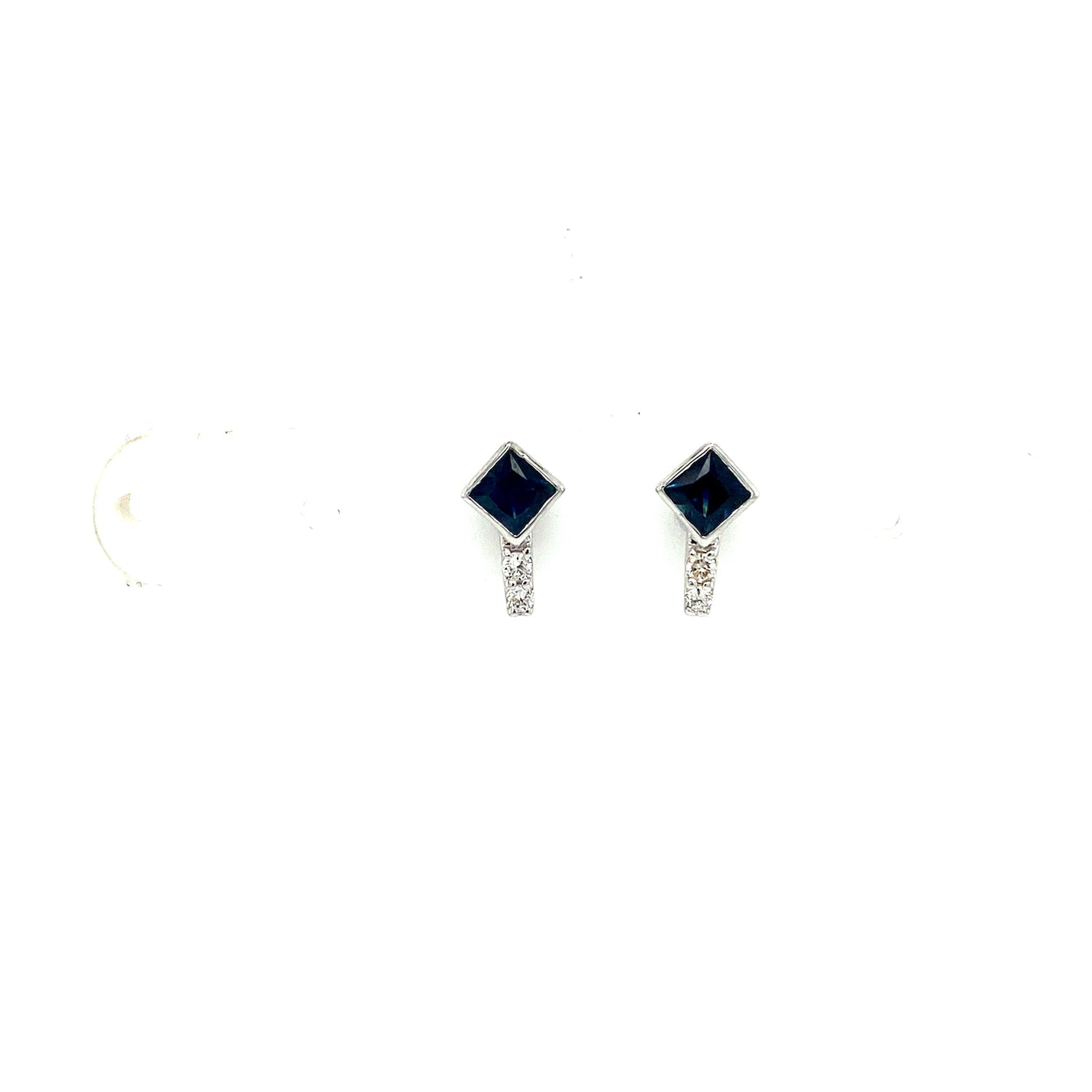 Silver earrings with dark blue diamond-shaped stones and small clear accents below.