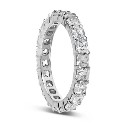 Silver eternity ring with square-cut clear stones, held by prongs, forming a continuous loop.