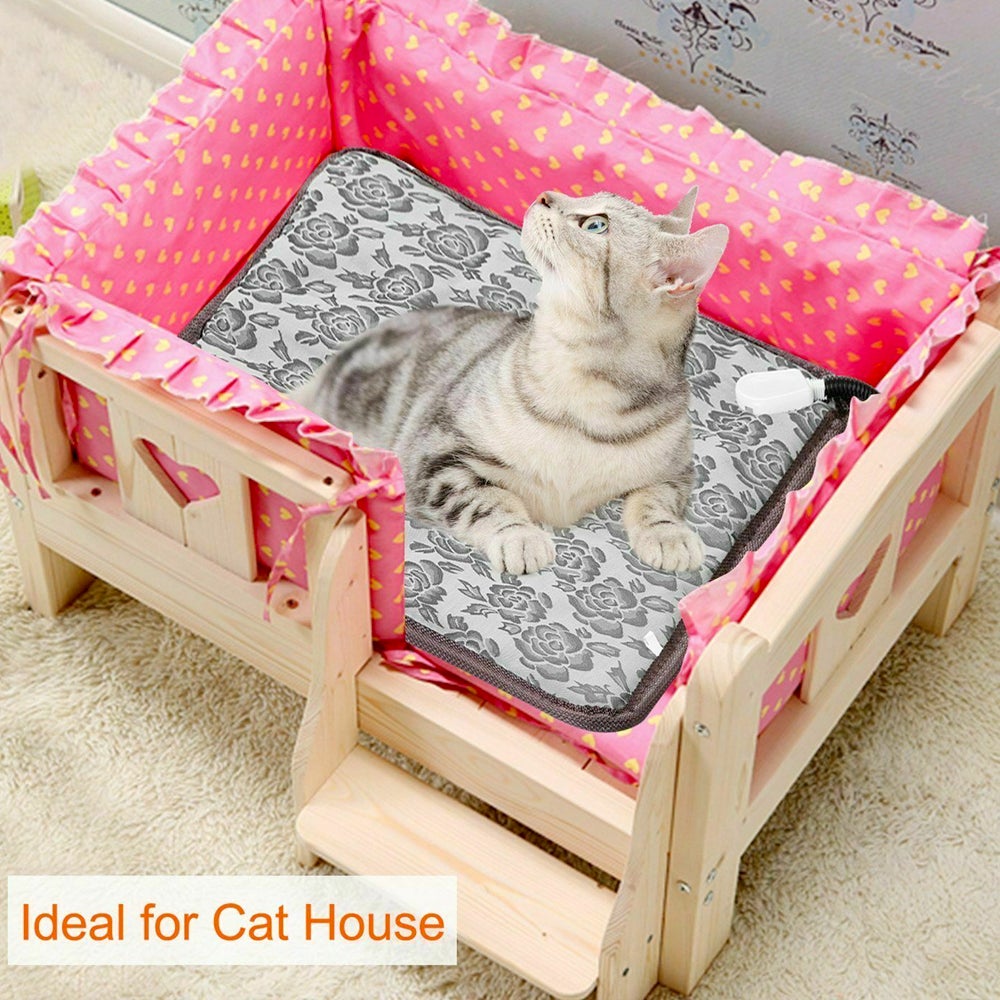 Cat in a wooden bed with pink heart-patterned fabric and a gray floral cushion.