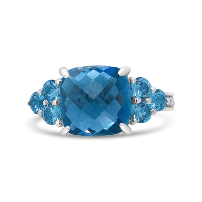 Silver ring with a large, faceted blue gemstone, flanked by smaller round blue stones.