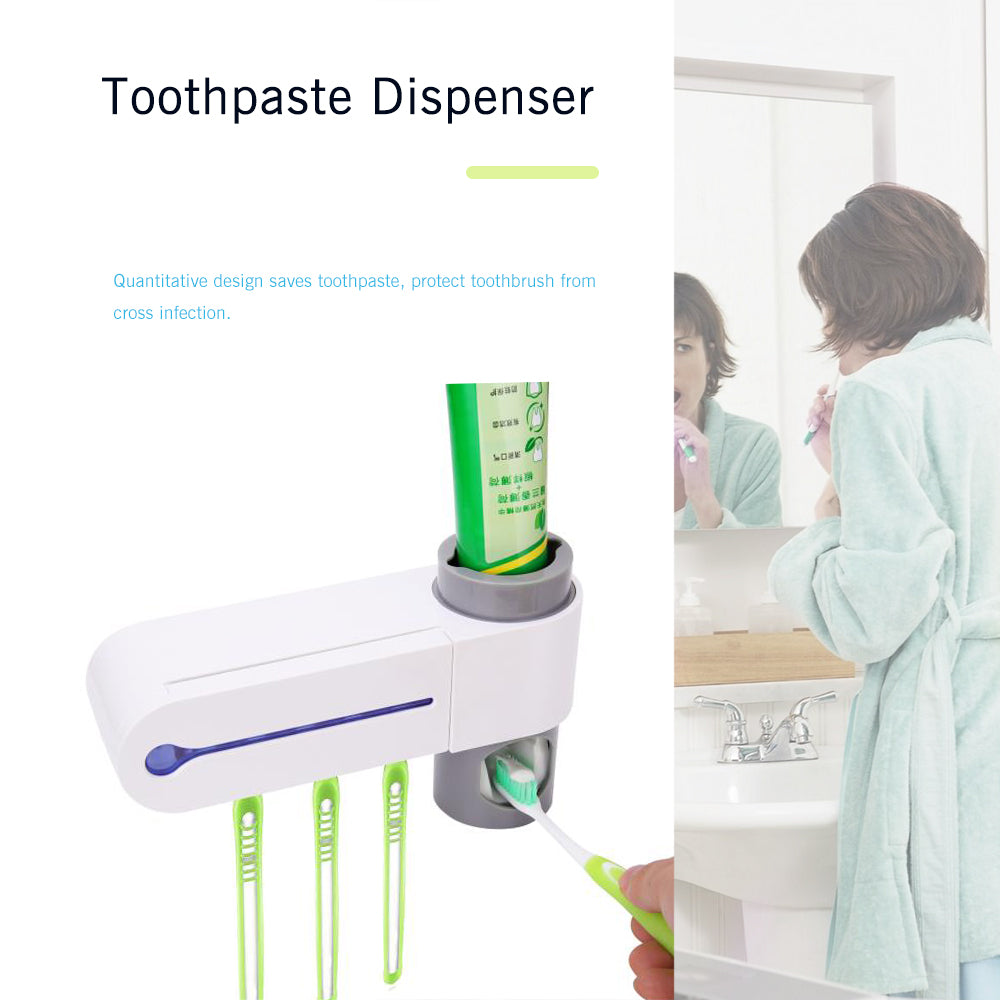 White toothpaste dispenser with four green toothbrush slots, woman brushing teeth in a bathroom.