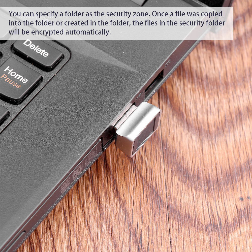 Close-up of a metal USB flash drive in a laptop on a wooden surface; text overlay above.