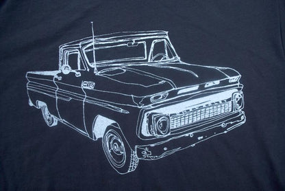 Line drawing of a vintage pickup truck on a dark fabric, outlined in white.