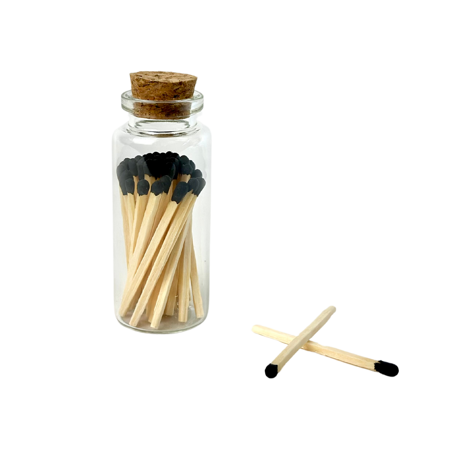 Jar of wooden matches with black tips, topped with cork; two matches crossed beside it.