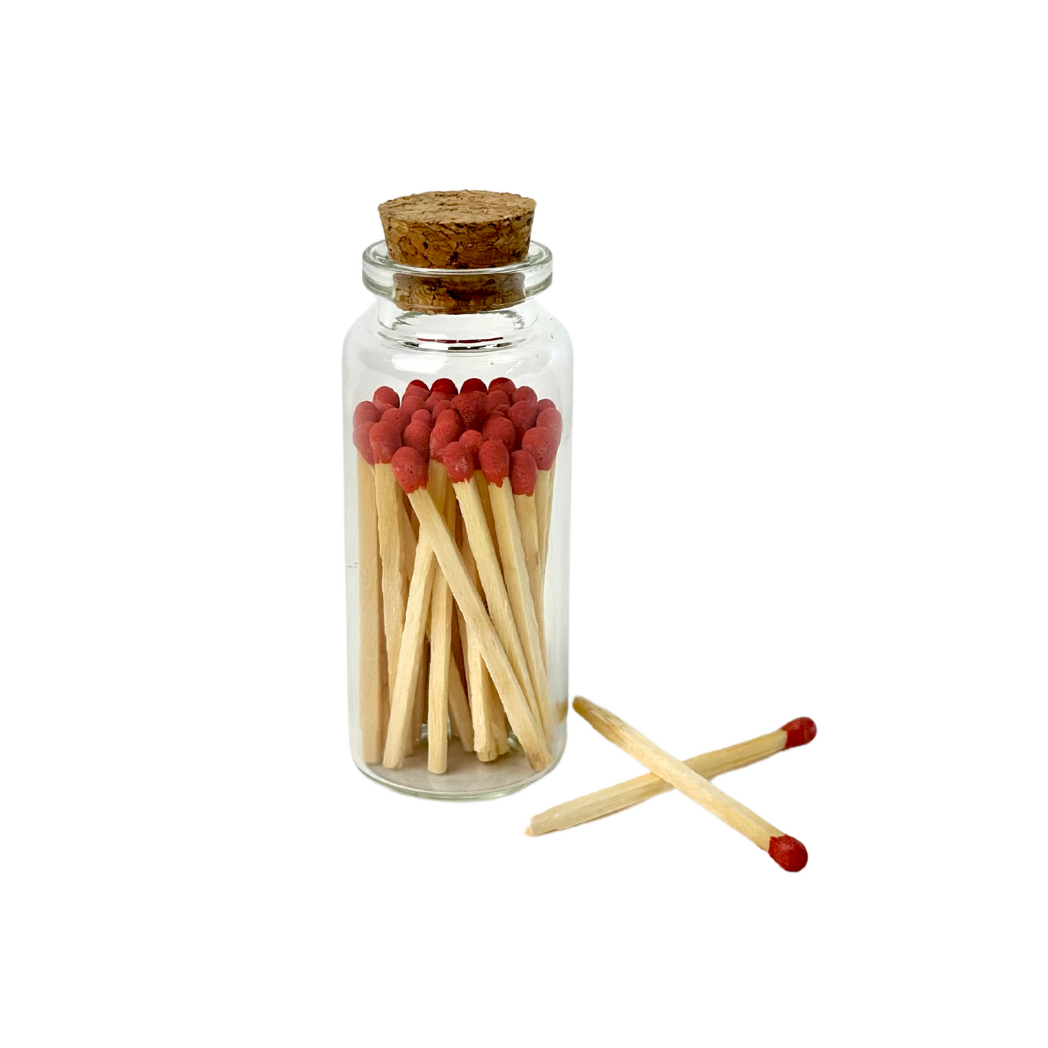Glass jar with cork top containing wooden matches with red heads, two matches lie beside it.