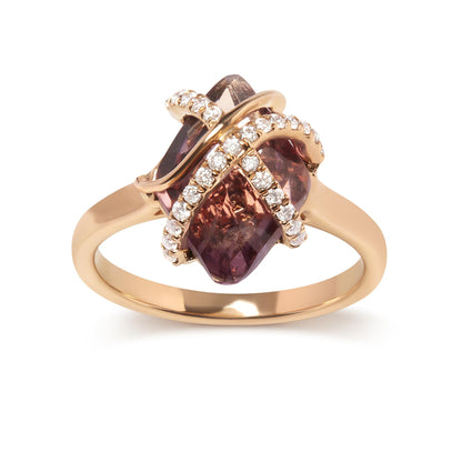Gold ring with a central dark pink stone wrapped in diamond-studded bands.