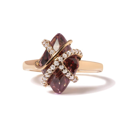 Gold ring with a large purple gem, crossed by two diamond-studded X-shaped bands.