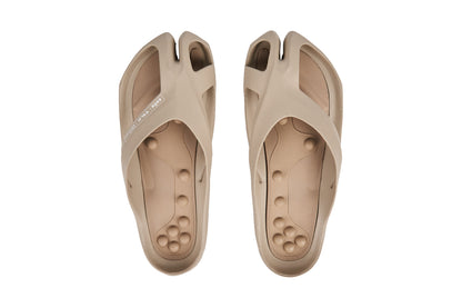 Beige split-toe sandals with textured footbed and wide straps, viewed from above.