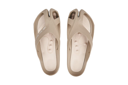 Beige split-toe sandals with crisscross straps and textured insoles.