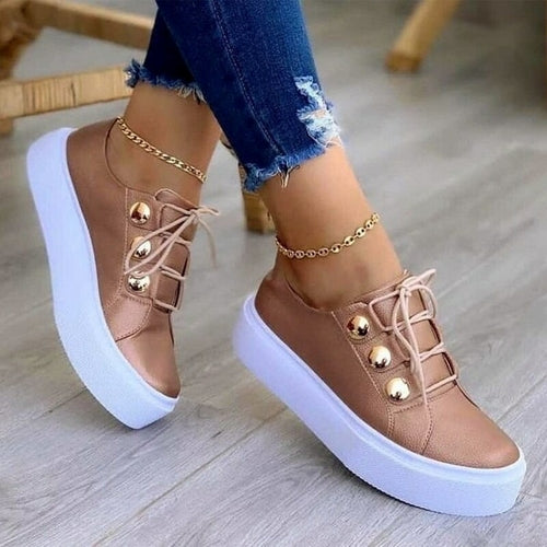 Rose gold sneakers with white platform soles, gold accents, worn with ripped jeans and anklets.