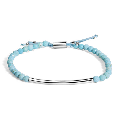 Silver bar bracelet with faceted light blue beads and adjustable cord.